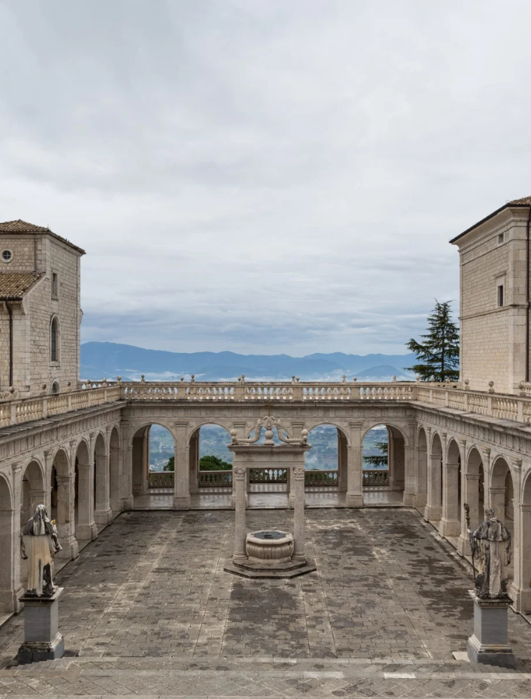 Il Chiostro del Bramante dell’Abbazia di Montecassino, con il pozzo centrale e la vista sulle montagne circostanti.